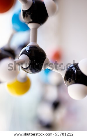 Close up of model of a chemical element made of black, blue, red and yellow parts