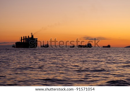 Ships anchored in the ocean with a beautiful sunset as a background/Ships in the sunset