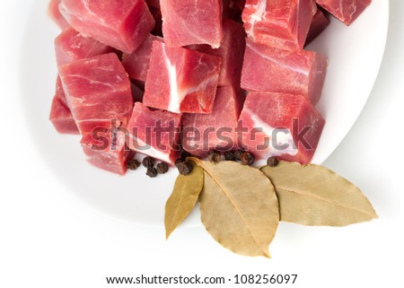 pieces of frozen meat with laurel leaves isolated