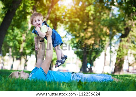 happy daddy with  baby in a greenl summer park