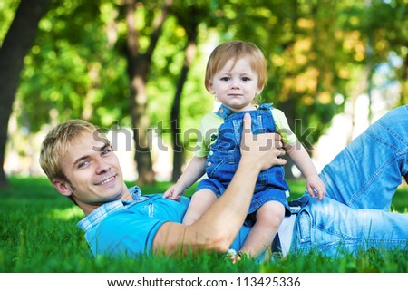 happy daddy with  baby in a greenl summer park