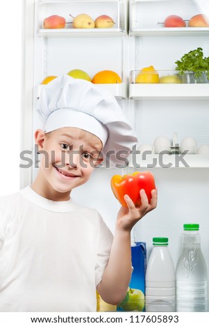 cute kid is choosing food near the open refrigerator