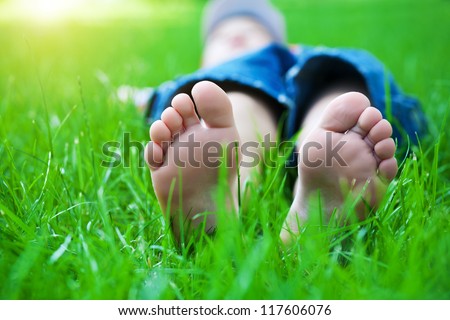 Children\'s feet  on grass. Family picnic in spring park
