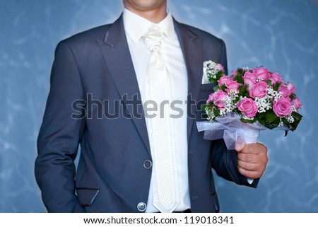 groom holding beautiful  flowers bouquet