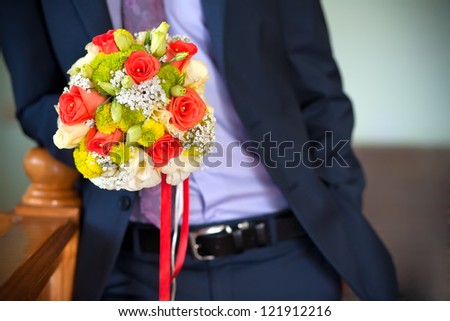 groom holding beautiful  flowers bouquet