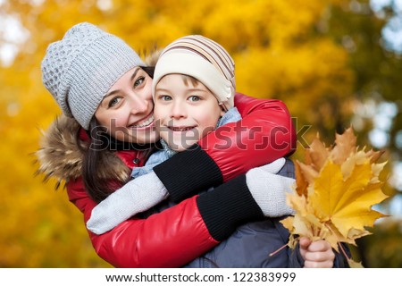 Mom and son on a autumn park background