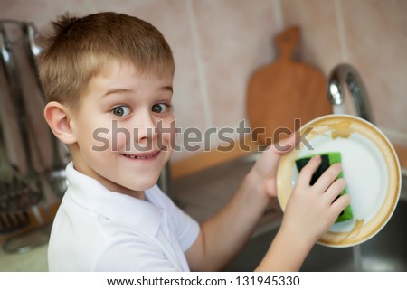 kid is washing dishes in the kitchen