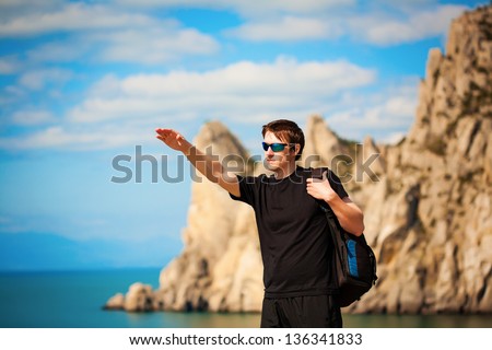 man tourist is pointing the way from the rocks top
