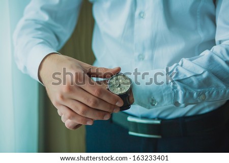 Businessman checking the time on his wrist watch