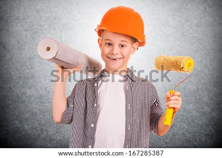 funny boy with a roll of wallpaper and brush