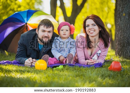 mother and father are playing with their daughter in the park