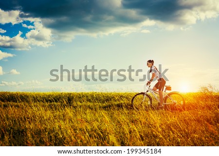 Happy Young Woman riding bicycle outside. Healthy Lifestyle.