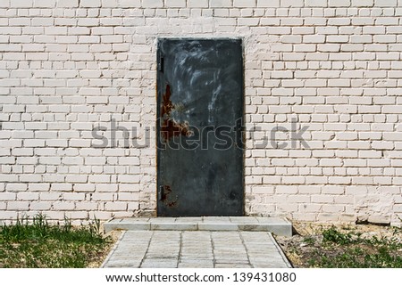 old brick wall with black door
