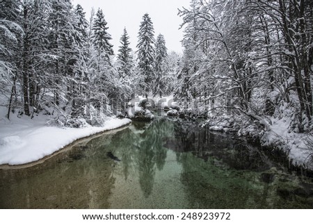 Winter Fairytale at Bohinj Lake in Slovenia. Mystical landscape on a winter day with heavy snow. Cottages reflection in the Snow.