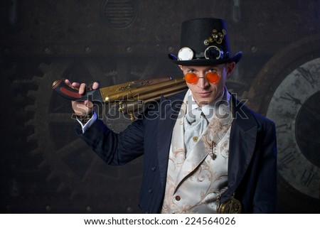 Portrait of a steam punk man over grunge dark background with the weapon
