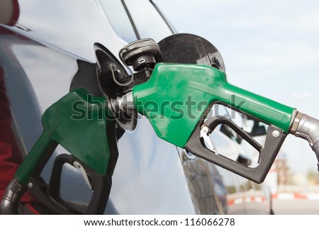 Pumping gas at gas pump.