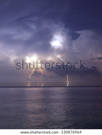 Lightning over sea and stars