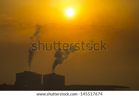 industrial smoke from chimney on red sky