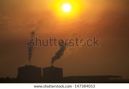 industrial smoke from chimney on red sky