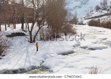 woman watching frozen river over the snow