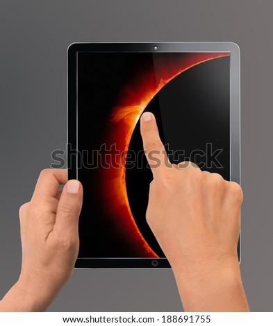 Woman looking in  Modern Tablet Device with  solar eclipse \