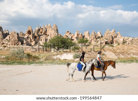 GOREME TURKEY JUNE 18: Tourists enjoy ride horses in Cappadocia on June 18 2014 in Nevsehir, Turkey. Cappadocia is part of the UNESCO World Heritage Site.