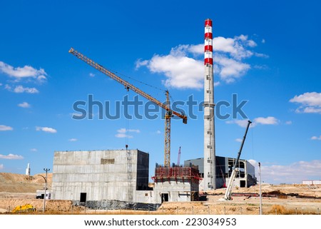 construction factory with tower crane over blue sky