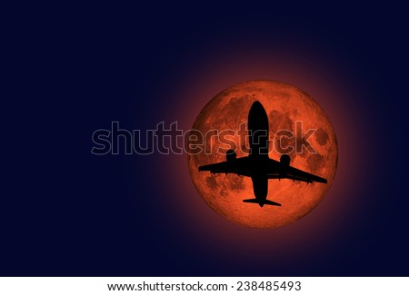 airplane flying across a full moon \