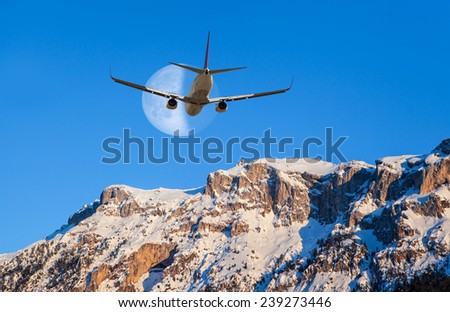 Airplane over the mountains against moon 