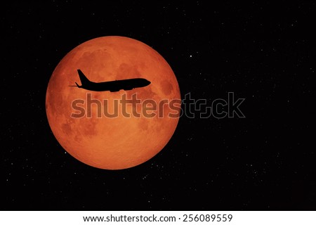 an airplane flying across a full moon 