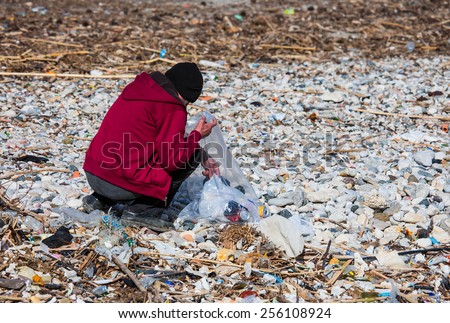 Man volunteer collecting garbage on beach