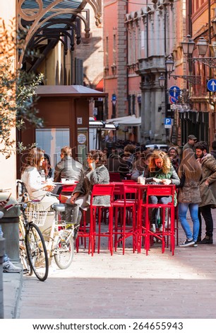 BOLOGNA, ITALY - MARCH 12,2015:Tourists Having Lunch At Outdoor Restaurant Downtown and  people gather around the Piazza Maggiore in Bologna