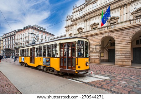 MILAN, ITALY - MARCH 24, 2015: La scala theatre Orange vintage tram in a street of Milan city center