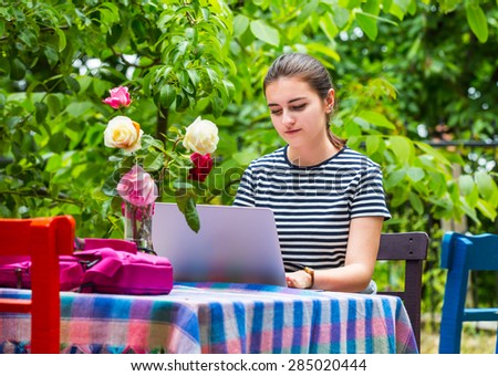 Young girl  with laptop computer in the orient garden