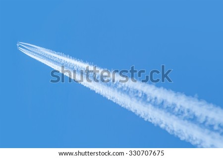 trail of white smoke from the airplane on blue sky