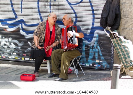 MADRID - JUNE 3: Unidentified couple sing and play for money in the street, June 3, 2012 in Madrid, Spain. A report shows 22% of households in Spain live below the poverty line.