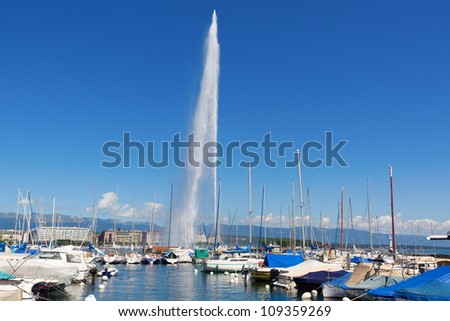Jet d\'Eau Geneva set against a blue sky and harbor with yachts