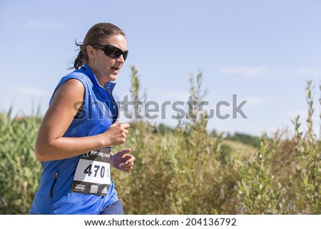 MACHILLY, FRANCE - JULY 6, 2014: Unidentified athlete participates in the running race of the Lake Machilly Triathlon which is part of the TriSaleve of Annemasse organization.