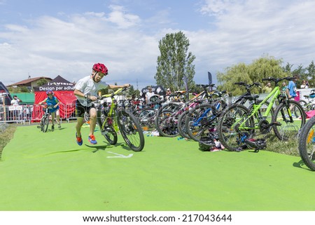 MACHILLY, FRANCE JULY 6, 2014: Unidentified young male athlete participates in the cycle race of the Lake Machilly Triathlon which is part of the TriSaleve of Annemasse organization.