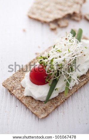 crisp bread sandwich with cream cheese, broccoli sprouts, tomato and chive