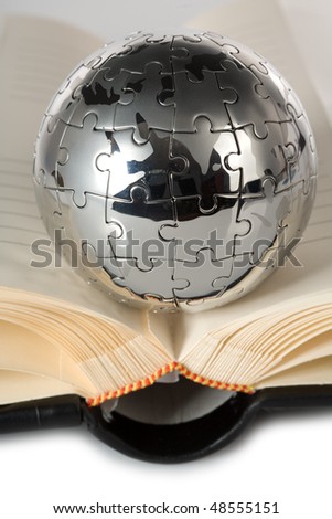 Globe puzzle with book on blue background.