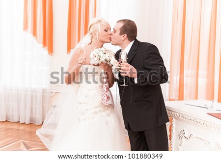 young groom and bride kissing in registry office