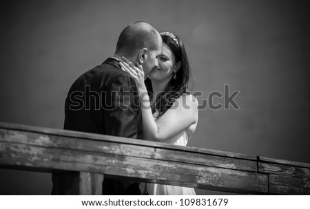 Black and white portrait of groom and bride kissing