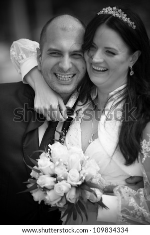 Black and white portrait of newly married couple laughing together