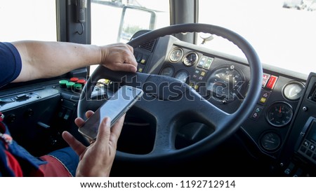 Closeup photo of irresponsible man typing phone number while driving truck. Danger in transport. Irresponsible driver