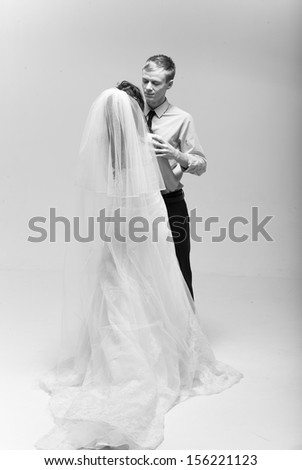 Black and white photo of groom hugging his groom