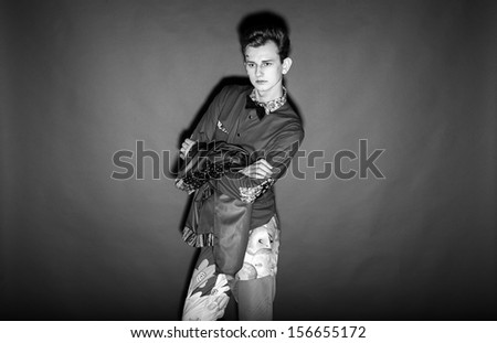 Black and white portrait of fashionable man posing against black background