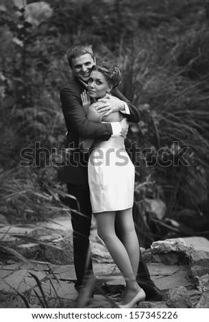 Black and white portrait of bride cuddling to groom