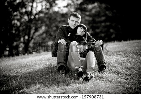 Black and white photo of couple in love sitting on lawn