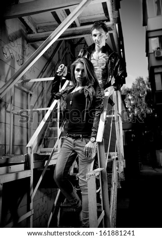 Black and white photo of couple in love walking down metal stairways